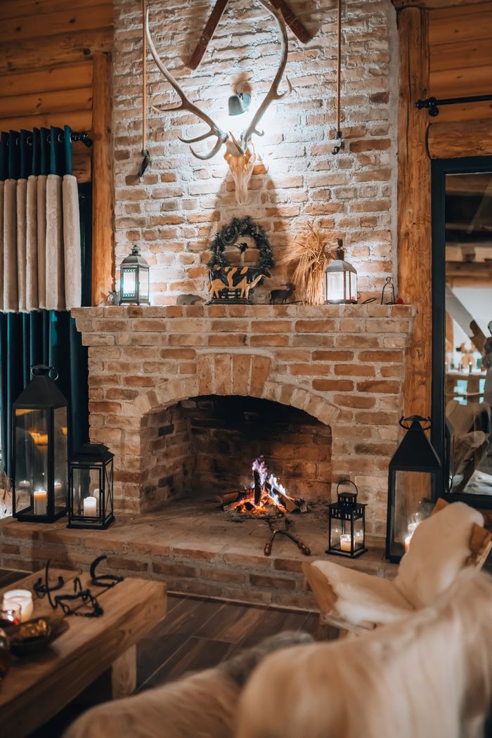 A warm, rustic living room featuring a brick fireplace and cozy decor.